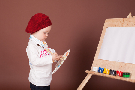 little boy artist brush and paints paints a pictureの写真素材
