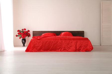 the Interior of the white room with a bed with red sheetsの写真素材
