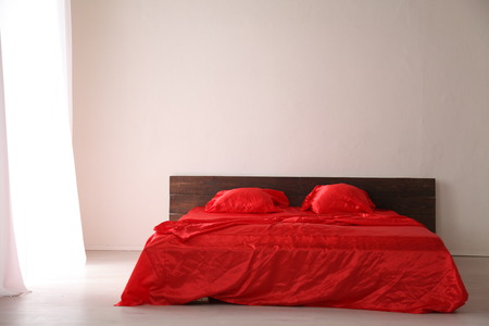 the Interior of the white room with a bed with red sheetsの写真素材