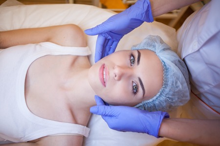 Cosmetology doctor makes woman treatments facial massageの写真素材