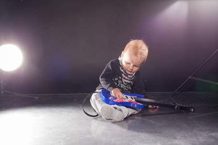little boy musician playing rock music on the guitarの写真素材