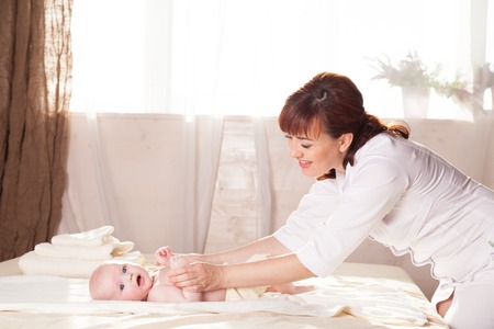 the little boy baby mother doing massage hands and legsの写真素材