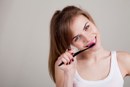 pretty girl in the bathroom brushing his teeth smileの写真素材
