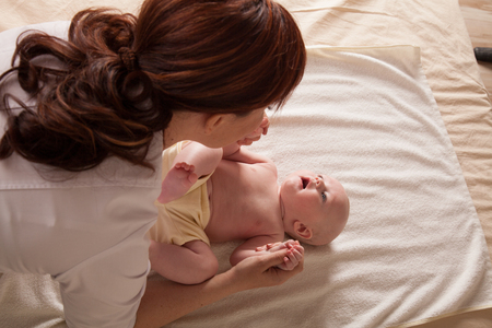 the little boy baby mother doing massage hands and legsの写真素材