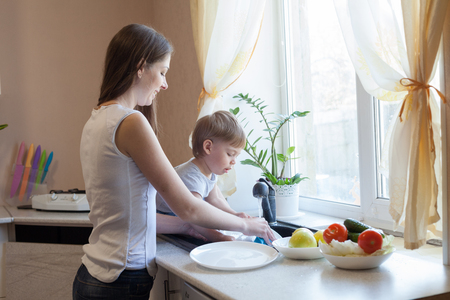 kitchen mom son wash fruits and vegetablesの写真素材