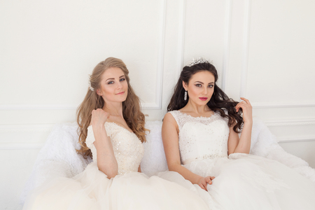 Portrait of two young women in wedding dresses in White Hallの写真素材