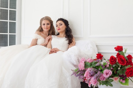 Portrait of two young women in wedding dresses in White Hallの写真素材
