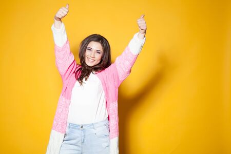 beautiful girl in colored clothing waving handsの写真素材