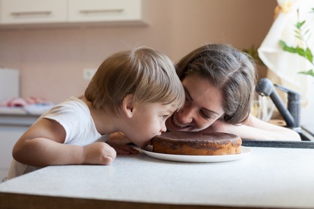 mother and son eating pie in the kitchenの写真素材