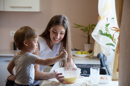 mother and young son prepare pie in the kitchenの写真素材