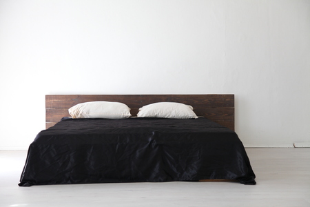 Interior white bedroom and bed with black sheetsの写真素材