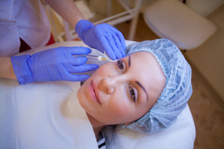 doctor beautician increases lip patient an injection syringeの写真素材