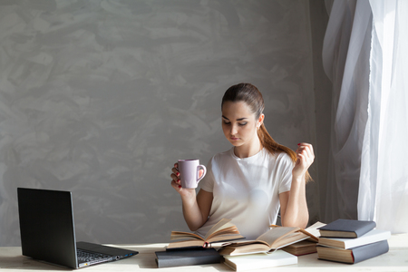 girl reading a book and drinking coffeeの写真素材