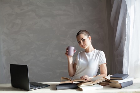 girl reading a book and drinking coffeeの写真素材