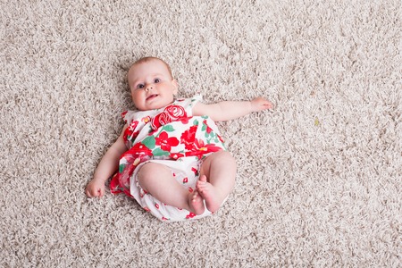 baby girl in a dress with red flowersの写真素材
