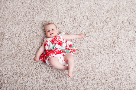baby girl in a dress with red flowersの写真素材
