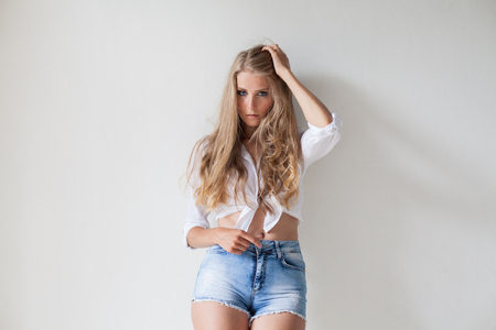 blonde in white wall fashion shorts shirtの写真素材
