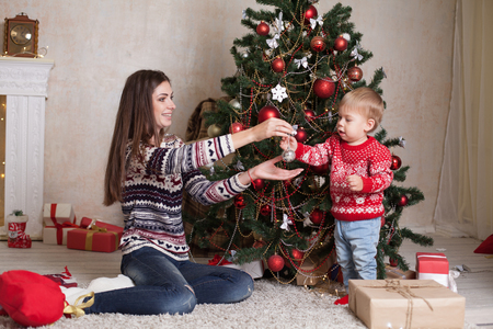 mom with son decorate tree on new years Gifts Christmasの写真素材