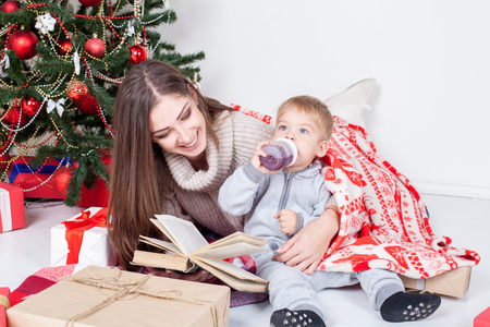 mother reading a book to a child at Christmas new yearの写真素材