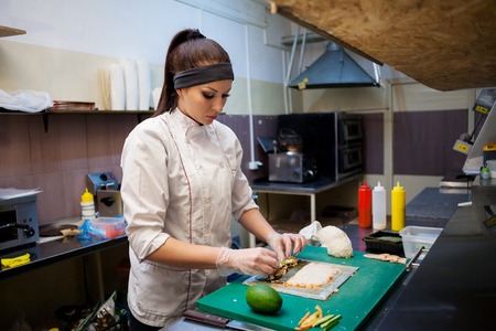female chef preparing a sushi restaurant in the kitchenの写真素材
