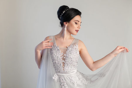 bride in wedding dress in white room