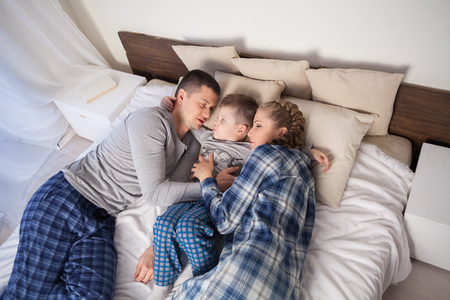 mom and dad and little boy in the bedroomの写真素材