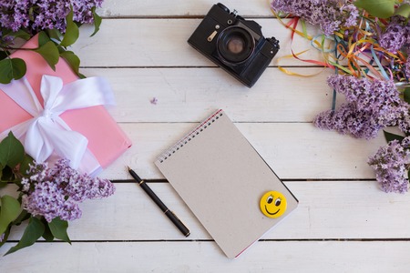 on the white table lies lilac, gift, notebook, cameraの写真素材