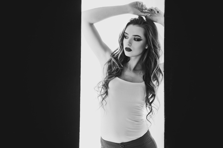 black and white photo of a beautiful woman in a doorwayの写真素材