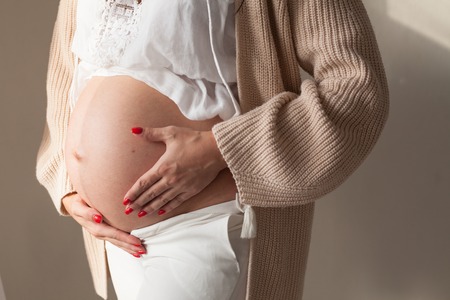 the stomach of a pregnant woman hands closeupの写真素材
