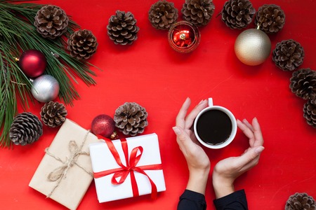 Christmas tree needles Cup of tea in the hands of the Red Christmas background Christmasの写真素材