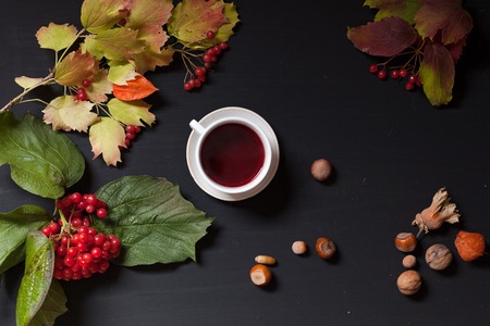 yellow and Red fall leaves coffee cup nuts on a black backgroundの写真素材