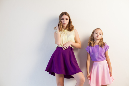 two fashionable girls sisters in beautiful clothes portraitの写真素材