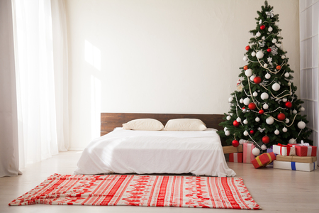 bedroom decor Christmas new year tree bed presents the background of the Interiorの写真素材