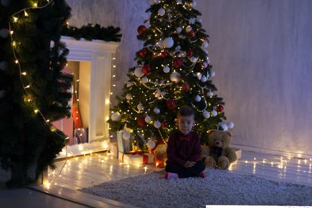 little boy opens Christmas presents new year Christmas tree Garlandの写真素材