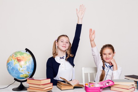 two girls in the classroom Learn lesson books at her desk globeの写真素材