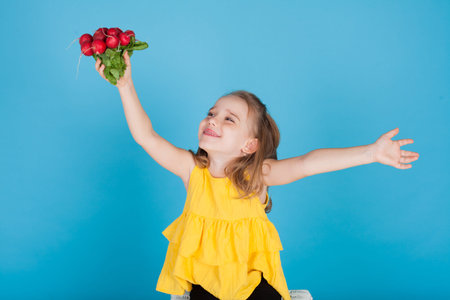 little girl with fresh vegetables red radishes
