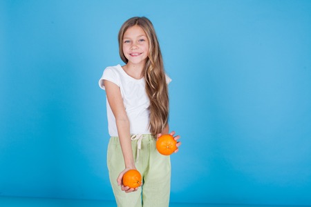 beautiful girl holding a ripe orange fruitの写真素材