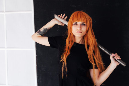 young woman in japanese anime cosplay, holding samurai sword.