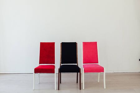 three chairs of red black and pink stand in the white roomの写真素材