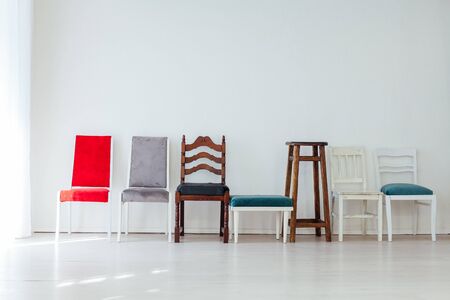many different chairs stand in the white room movingの写真素材