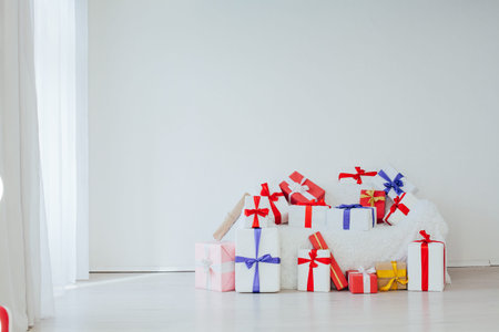 sofa in the interior of a white room with colorful gifts for the holiday surprise
