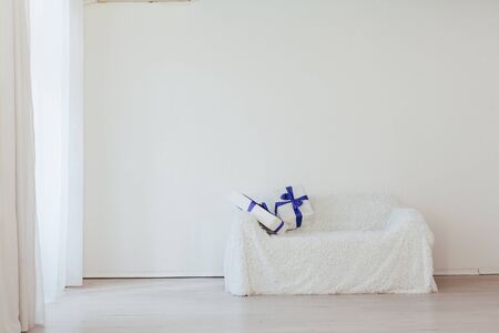blue gifts on the sofa interior of the white room decorの写真素材