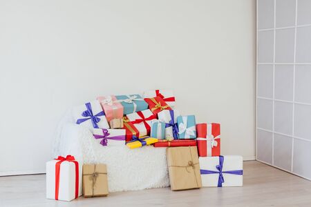 A lot of colorful gifts on the sofa in the interior of the white roomの写真素材