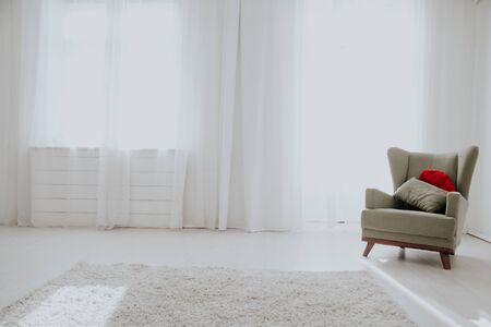 green chair in the interior of the white room with windowsの写真素材