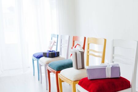 multicolored chairs with gifts in the interior of an empty white roomの写真素材
