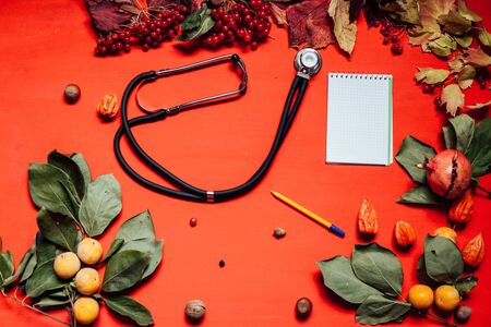 medical stethoscope fruits nuts colorful leaves on the background for breakfast lunch dinnerの写真素材
