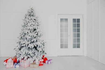 White room Christmas tree with red toys new year winter giftsの写真素材