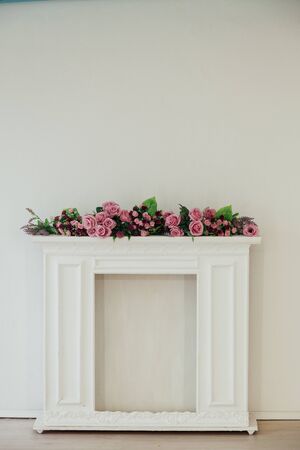 white fireplace with pink flowers against the wall in the roomの写真素材