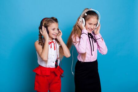 Beautiful schoolgirl girl listens to music in big headphonesの写真素材