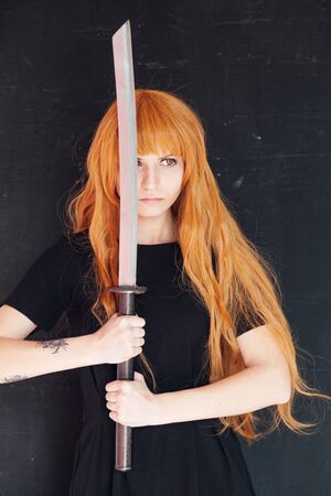 fashionable woman with red hair anime japan swordの写真素材